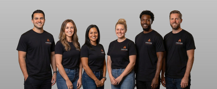 Group of six people wearing black t-shirts with a logo on a gray background
