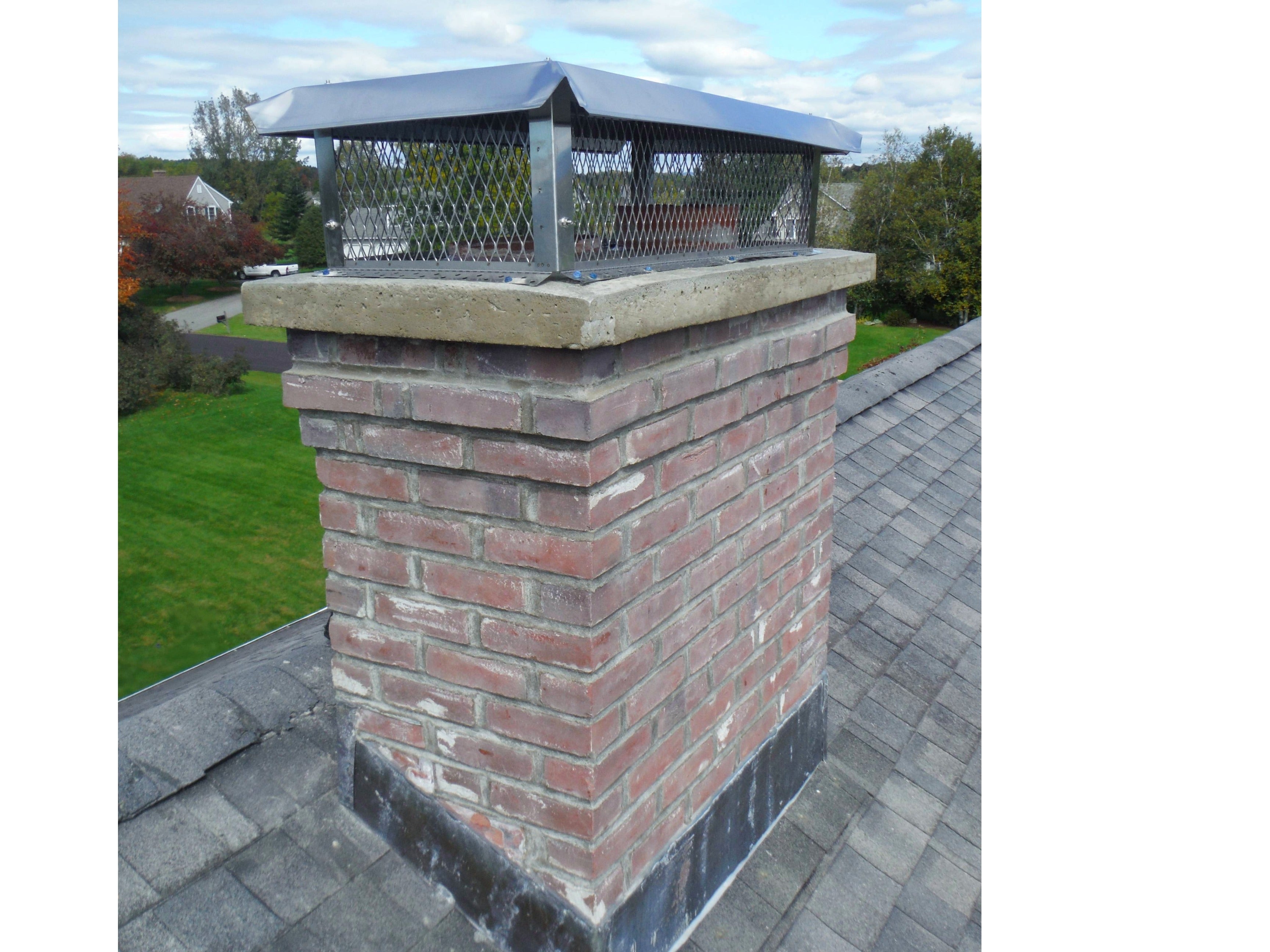 brick chimney with a stainless steel knockdown style chimney cap